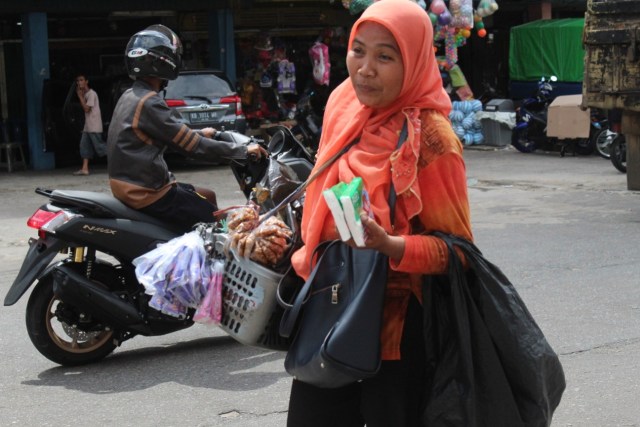 Bu Vivi perantau asal Sumatera yang bekerja sebagai pedagang asongan di pasar Kapuas Pontianak. Foto: Resi Jesita/Hi!Pontianak