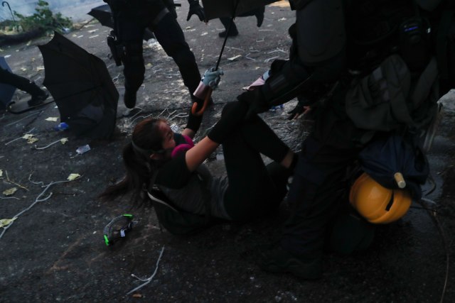Polisi anti huru hara bentrok dengan seorang pendemo. Foto: REUTERS/Jorge Silva