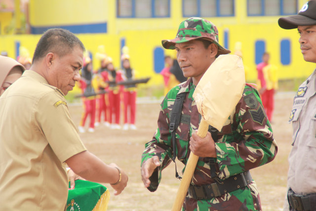 Bupati Buton Selatan H. La Ode Arusani menyerahkan alat kerja bangunan kepada perwakilan personil TNI sebagai simbol pelaksanaan TMMD ke-106 dimulai, Foto: Rusman/kendarinesia.