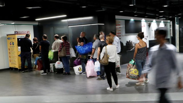 Sejumlah penumpang mengantre untuk menukar botol plastik di mesin daur ulang di Stasiun Metro San Giovanni di Roma, Italia. Foto: REUTERS/Remo Casilli