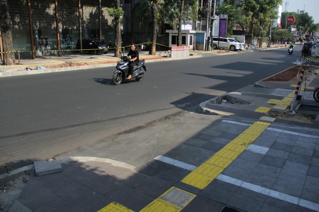 Pengendara motor melintas di samping revitalisasi trotoar Kemang, Jakarta, Jumat (4/10). Foto: Nugroho Sejati/kumparan