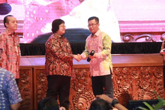 Menteri Lingkungan Hidup dan Kehutanan RI, Siti Nurbaya saat menyerahkan penghargaan kepada Wali Kota Palembang, Harnojoyo yang diwakilkan oleh Kepala DLHK Palembang, Alex Ferdinandus. (foto: Humas pemkot Palembang)