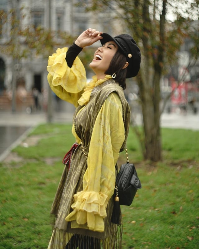 Selama di Belgia, Yuni tampak mengenakan atasan kain ulos yang terbuat dari bahan dasar kunyit dan daun ketapang karya Merdi Sihombing. Foto: Instagram @yunishara36