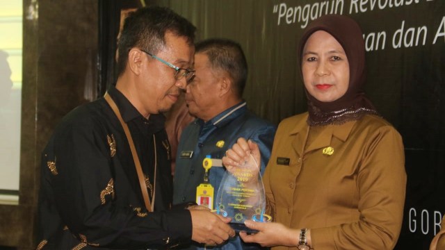 Sekretaris Daerah Kabupaten Gorontalo, Hadijah Tayeb, saat menerima penghargaan opini Wajar Tanpa Pengecualian (WTP). Selasa, (08/10). Foto : Humas Pemkab