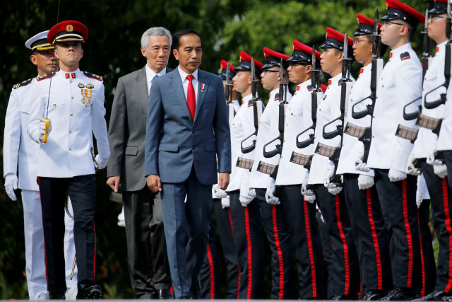 Presiden Joko Widodo (keempat kiri) didampingi PM Singapura Lee Hsien Loong (ketiga kiri), melakukan inspeksi pasukan, di Istana, di Singapura, Selasa (08/10).  Foto: ANTARA FOTO/REUTERS/Feline Lim