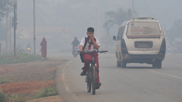 Pelajar di Kabupaten Tanjungjabung Timur beraktivitas di Jalan Lintas Jambi-Muara Sabak yang diselimuti kabut asap karhutla. Foto: ANTARA FOTO/Wahdi Septiawan