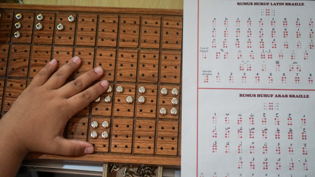 Pengunjung mencoba alat menulis dan membaca huruf braille Balai Literasi Braille Indonesia (BLBI) Abiyoso pada acara Gelar Pustaka dan Arsip Solo 2019 di kantor Dinas Kearsipan dan Perpustakaan Kota Surakarta (Disarpus) Solo, Jawa Tengah. Foto: ANTARA FOTO/Mohammad Ayudha