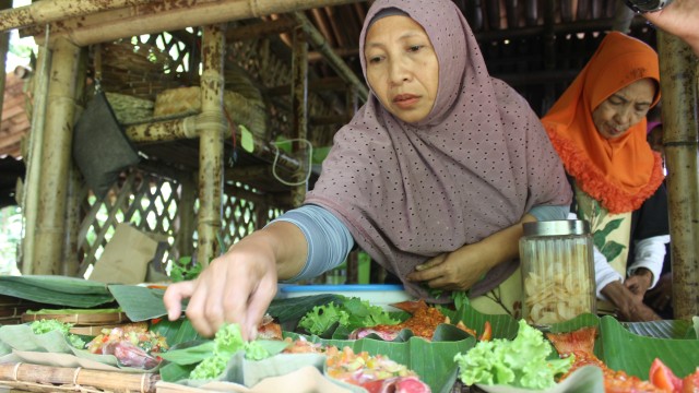 Salah satu pengurus Cengkeh Afo dan Gamalama Spices (CAGS) saat menyajikan kuliner khas Maluku Utara di cengkeh afo. Foto: Faris Bobero/cermat