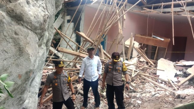 Wakil Bupati Purwakarta H. Aming (tengah) saat meninjau rumah warga yang rusak akibat runtuhan batu raksasa. Foto: Dok. Istimewa