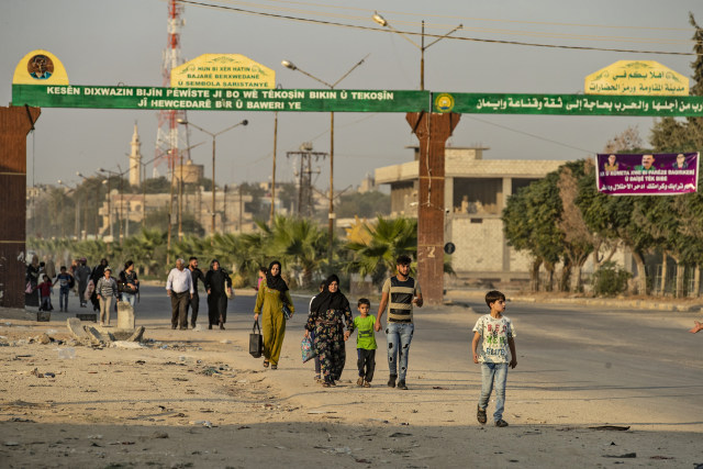 Masyarakat berjalan kaki meninggalkan kota Ras al Ain, Suriah. Foto: REUTERS/Rodi Said