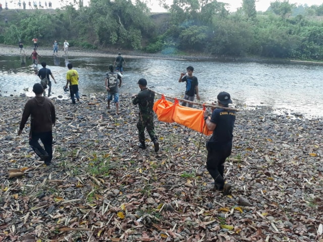 Petugas kepolisian dan anggota TNI bersama warga saat melakukan evakuasi terhadap jenazah korban (foto: iistimewa)