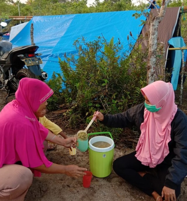 Siti Rahmi (kanan) saat layani pengungsi memberikan sarapan pagi. Dok : Abu