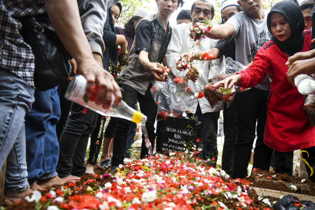 Keluarga dan kerabat menaburkan bunga usai memakamkan korban demo ricuh Akbar Alamsyah di TPU kawasan Cipulir, Kebayoran Lama, Jakarta, Jumat (11/10/2019). Foto: ANTARA FOTO/Galih Pradipta