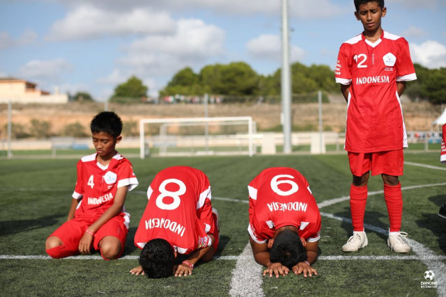 Para pemain Indonesia di turnamen 2018 bersujud syukur setelah meraih kemenangan pada sebuah laga di Danone Nations Cup. Foto: Martina Cristofani/SIPA/DNC