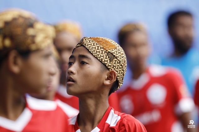 Salah seorang pemain dari tim Indonesia di turnamen 2018 Danone Nations Cup mengenakan belangkon. Foto: Kamil Zihnioglu/SIPA/DNC