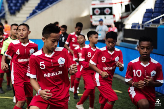 Para pemain Indonesia melakukan pemanasan sebelum melakoni laga melawan Prancis di turnamen 2019 Danone Nations Cup. Foto: Kamil Zihnioglu/SIPA/DNC