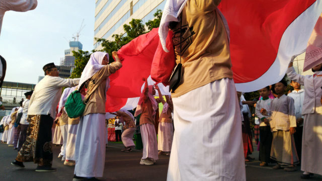 Pengibaran bendera merah putih sepanjang 740 meter dalam peringatan hari santri nasional di Jalan MH Thamrin, Jakarta Pusat, Minggu (13/10/2019). Foto: Fachrul Irwinsyah/kumparan