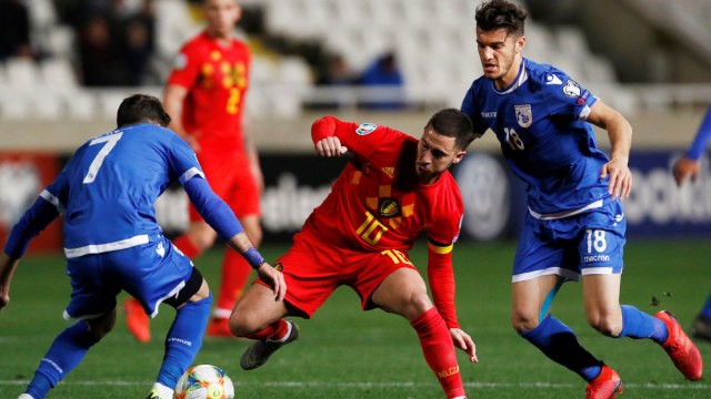 Eden Hazard berduel pada laga Siprus vs Belgia. Foto: REUTERS/Yiannis Kourtoglou