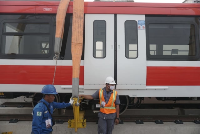 Pekerja di samping rangkaian kereta LRT di Stasiun LRT Harjamukti Cibubur, Jakarta Timur. Foto: Iqbal Firdaus/kumparan