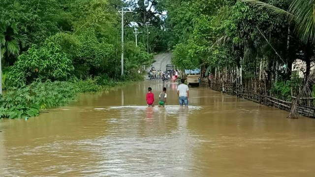 Warga melintasi genangan banjir luapan akibat hujan deras yang mengguyur kawasan tiga kecamatan di Kabupaten Nagan Raya, Aceh. Foto: Dok BPBD Nagan Raya 
