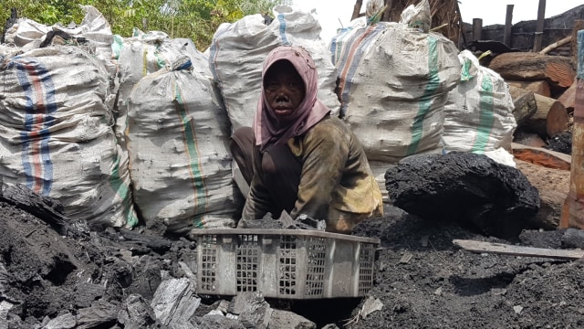 Wajah buruh wanita dipenuhi jelaga hitam pembakaran arang di Desa Buluhrejo, Kecamatan Mantewe, Kabupaten Tanah Bumbu. Foto: banjarhits.id
