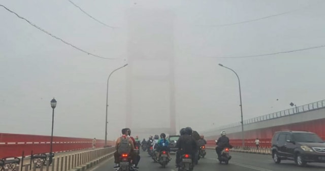 Jembatan Ampera yang tertutupi kabut asap di sore hari. (foto: abp/Urban Id)
