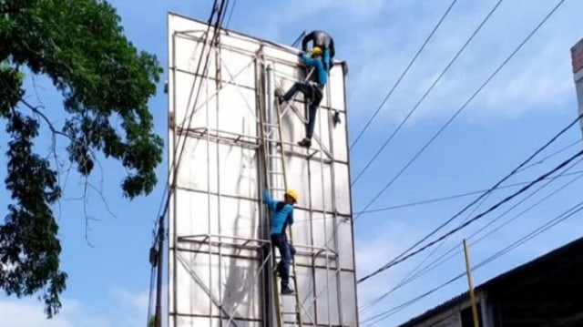 Pekerja papan reklame tersengat listrik tegangan tinggi dan berhasil diselamatkan petugas. Foto: Dok. Istimewa
