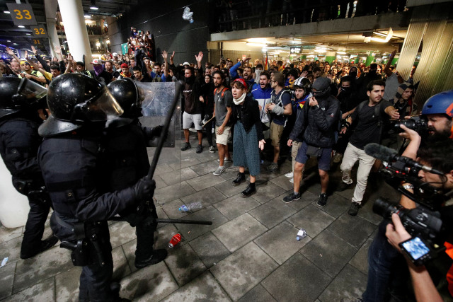 Demonstran bentrok dengan polisi di Bandara Barcelona memprotes vonis pemimpin Catalunya di Barcelona, Spanyol, Senin (14/10/2019). Foto: REUTERS/Albert Gea