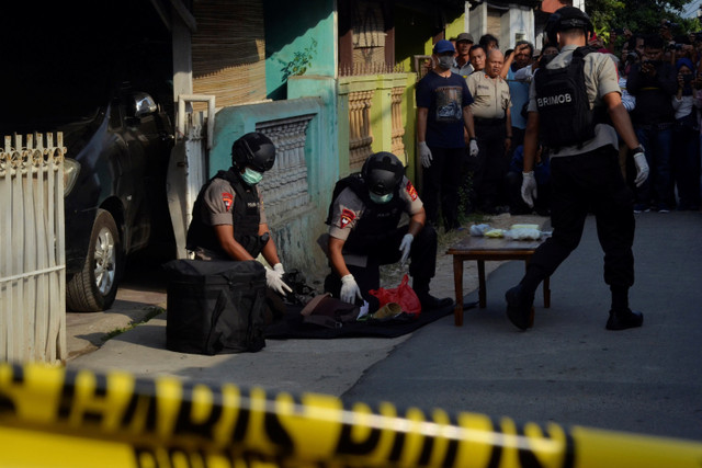 Personel Brimob Polda Lampung mengumpulkan sejumlah barang bukti usai penggeledahan rumah milik orang tua terduga teroris di Bandar Lampung, Lampung.  Foto:  ANTARA FOTO/Ardiansyah 