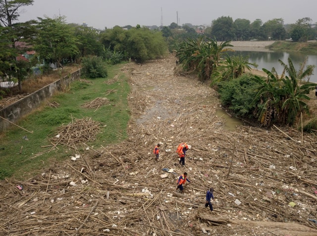 Petugas gabungan membersihkan tumpukan sampah yang menyumbat aliran air Sungai Cikeas, di kawasan Jatiasih, Bekasi, Jawa Barat, Selasa (15/10/2019). Foto: ANTARA FOTO/Risky Andrianto