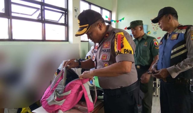 Kapolsek Sukomanunggal Kompol Muljono memeriksa tas para siswa SMP untuk mengecek HP, antisipasi fenomena geng di Surabaya