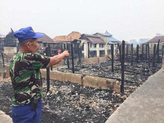 Salah satu warga menunjukkan lokasi rumah ayah Kapolri Jenderal Tito Karnavian yang hangus terkabar. (Foto: Gonti Hadi Wibowo/Ur-ban.id)
