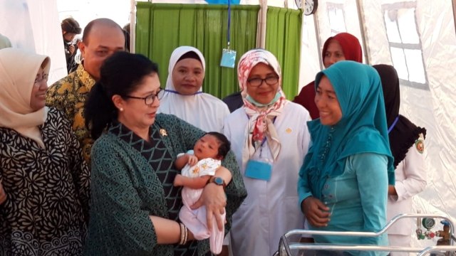 Menteri Kesehatan Nila Djuwita F Moeloek menggendong bayi yang baru dilahirkan di rumah sakit darurat dr. Umarella di Tulehu, Maluku Tengah (Foto: ambonnesia)