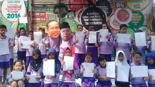 Siswa SD di Solo menunjukkan gambar wajah Presiden Jokowi. (Weni S)