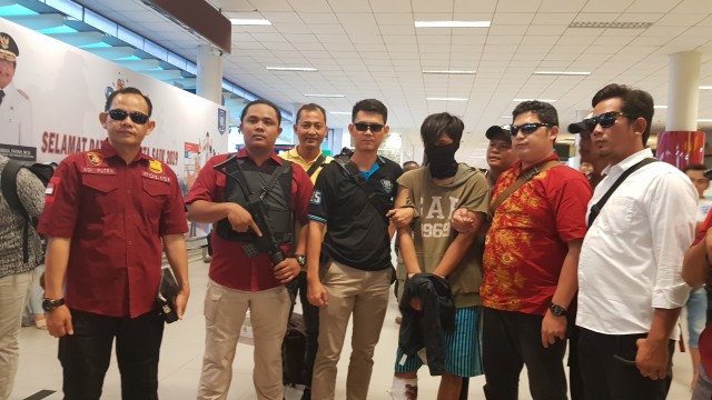 Kapolsek Bukit Intan, AKP Adi Putra saat membawa Pelaku Yolan yang tiba di Bandara Depati Amir, Bangka Belitung. (Jr/Babelhits)