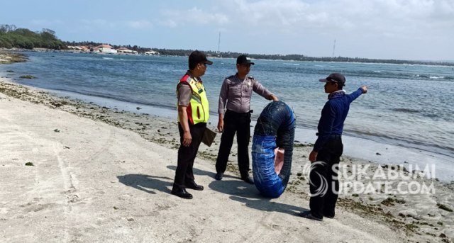 Polisi mengecek tubing yang digunakan korban saat dihempas ombak di pantai Ujung Genteng | Sumber Foto:RAGIL GILANG