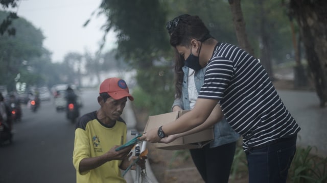 Tim Urban Id saat menyalurkan masker dari Kumparan kepada warga Palembang di kawasan Kambang Iwak. (foto: Ary Priyanto/Urban Id))