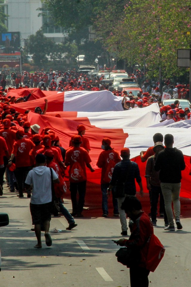 Relawan mengibarkan bendera merah putih saat mengikuti pesta rakyat di kawasan Patung Kuda, Jakarta, Minggu (20/10/2019). Foto: AFP/DANY KRISNADHI
