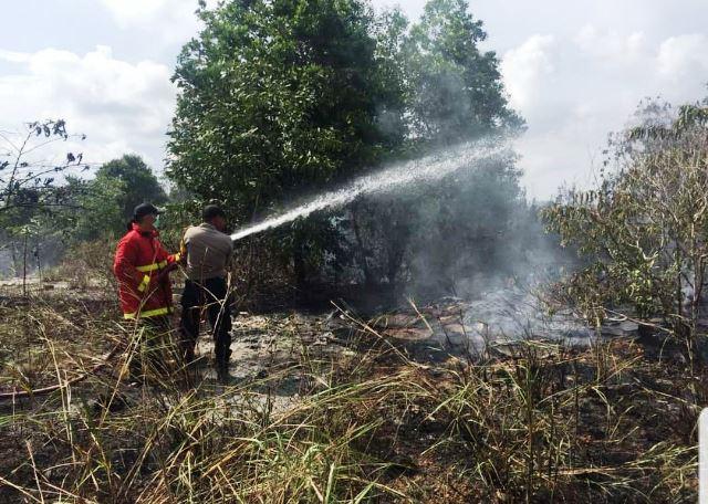 Petugas PBK dan kepolisian memadamkan api yang melalap lahan di Seilekop, Bintan. (Foto: Ari/batamnews)