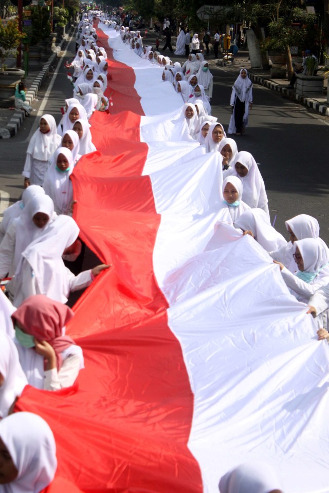 Santri membawa bendera merah putih sepanjang 1.000 meter saat pawai peringatan Hari Santri Nasional di Sidoarjo, Jawa Timur, Minggu (20/10/2019). Foto: ANTARA FOTO/Ari Bowo Sucipto