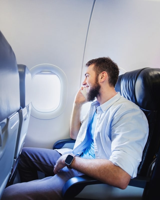 Ilustrasi pria membuat panggilan telepon di pesawat (portrait) Foto: Shutter Stock