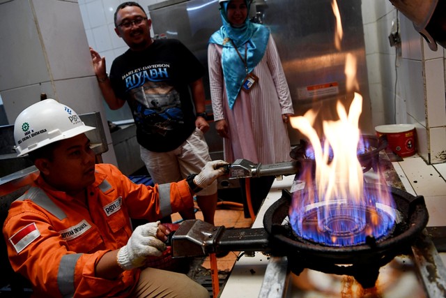 Petugas mencoba kompor yang menggunakan jaringan gas bumi PGN di salah satu pelanggan kecil usaha katering di Surabaya, Jawa Timur, Selasa (22/10/2019).  Foto: ANTARA FOTO/Zabur Karuru