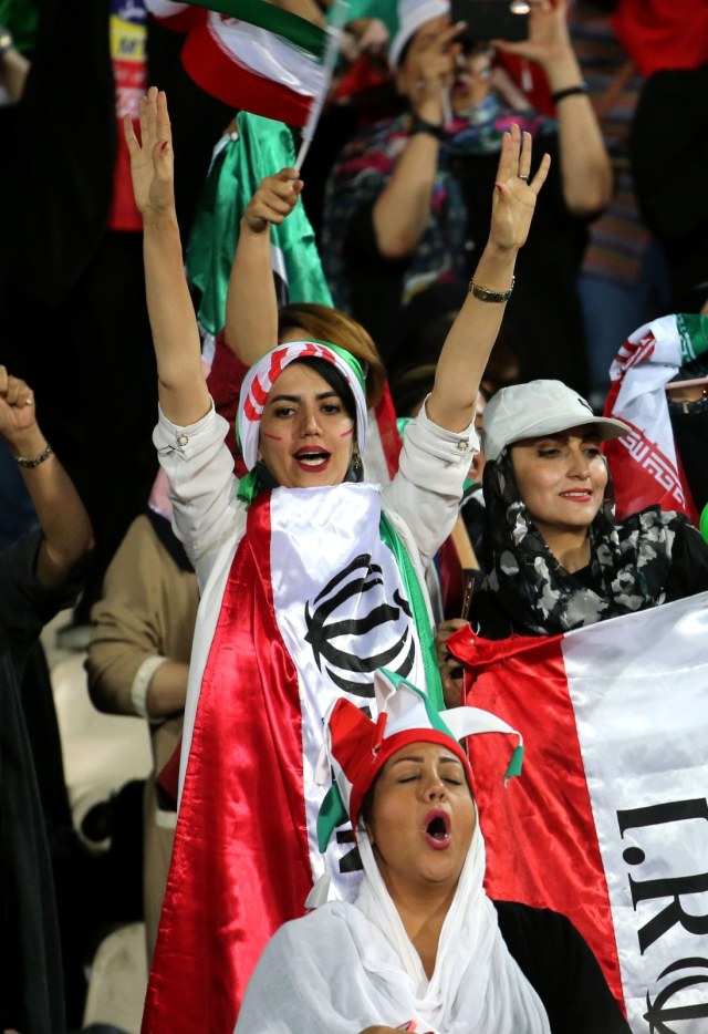 Suporter perempuan menyaksikan laga Iran vs Kamboja. Foto: AFP/Atta Kenare