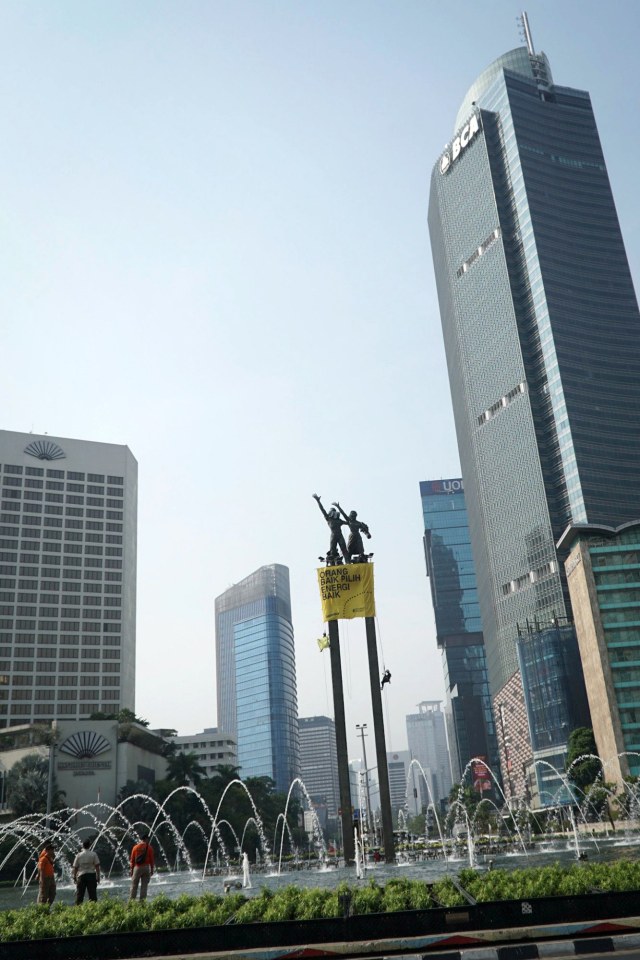 Aksi pemasangan spanduk di Bundaran HI, Jakarta Pusat, pada Rabu (23/10). Foto: Jamal Ramadhan/kumparan