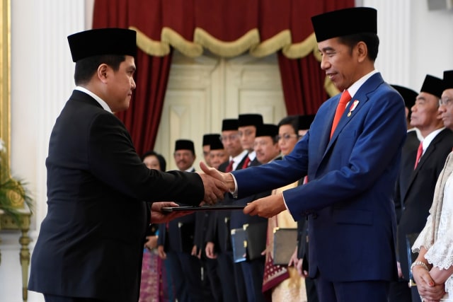 Presiden Joko Widodo (kanan) menyerahkan petikan keputusan kepada calon Menteri BUMN Erick Thohir di Istana Merdeka, Jakarta. Foto: ANTARA FOTO/Puspa Perwitasari