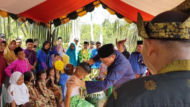 Salah satu tokoh adat saat memandikan anak secara simbolis. Foto : Hasrullah/kepripedia.com