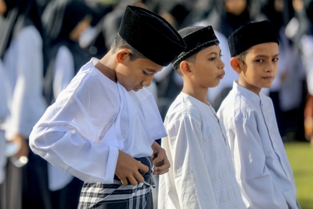 Seorang santri membetulkan sarungnya pada upacara peringatan puncak Hari Santri Nasional 2019 di Aceh, Kamis (24/10). Foto: Suparta/acehkini