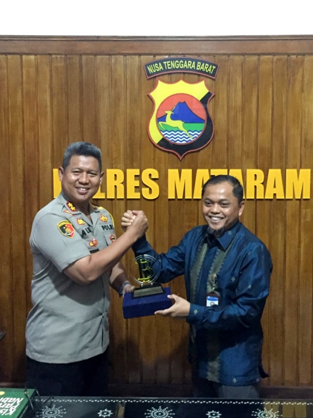 Kepala Perwakilan Bank Indonesia wilayah NTB, Achris Zarwani memberikan penghargaan kepada Kapolres Mataram AKBP Saiful Alam, terkait pemberantasan uang palsu. Foto: Ricky Febrian/kumparan