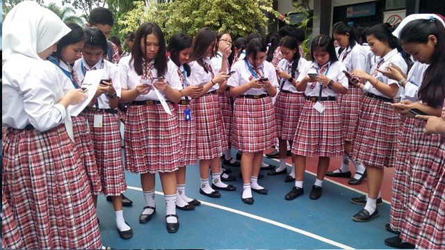 Siswa SMK Yadika Manado menggunakan handphone mereka untuk memilih pengurus Osis di sekolah mereka. SMK ini sudah dua tahun berturut-turut menggunakan metode e-Voting dalam pemilihan pengurus Osis