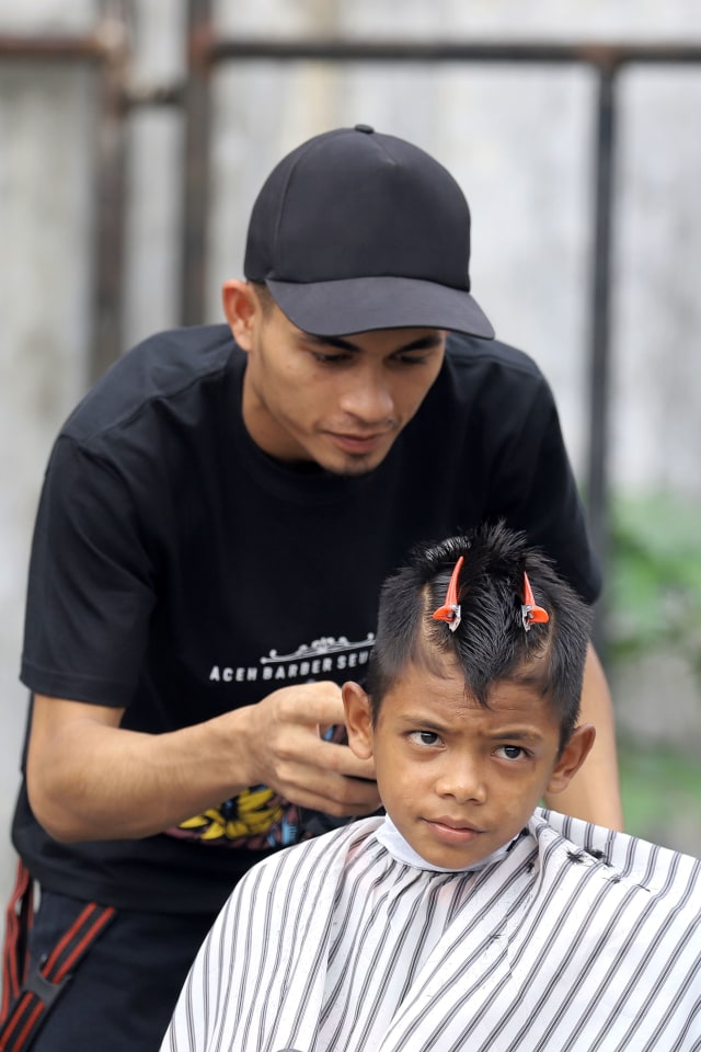 Aksi barberman Aceh memangkas rambut anak Panti Asuhan Nirmala, Banda Aceh. Foto: Windy Phagta 